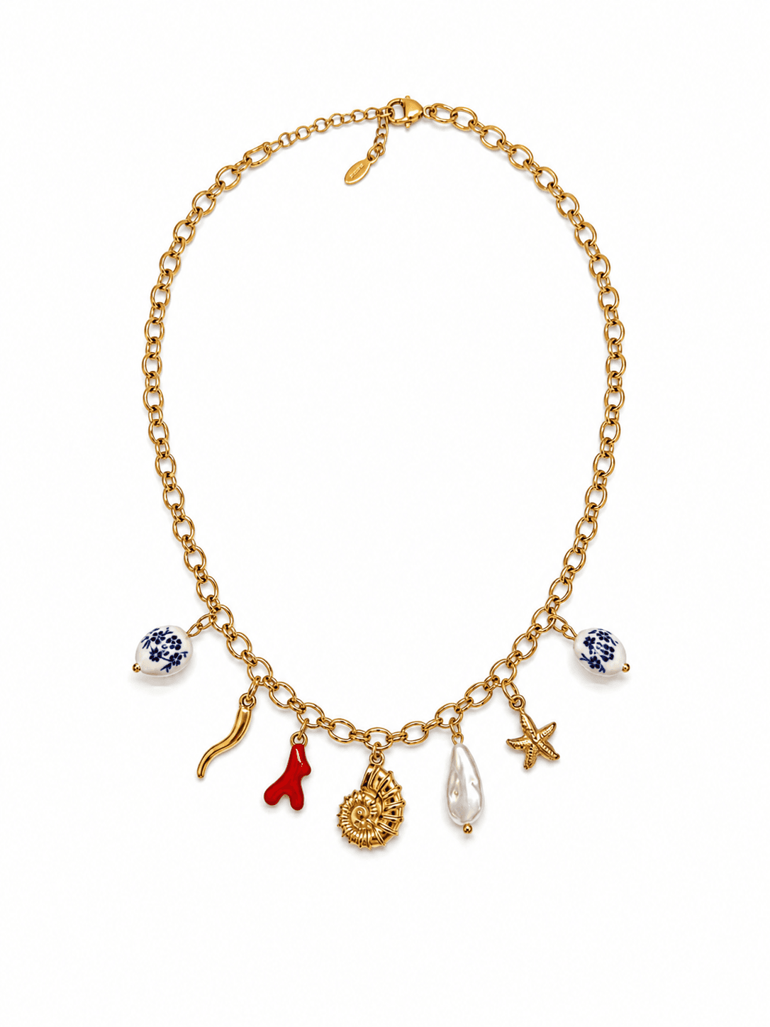 Collier Lavanda à plat sur fond blanc studio, chaîne forçat d'or et 7 pendentifs visibles — perles de faïence bleu Moustiers, cornicello d'or, brin de corail rouge, médaillon soleil, perle baroque blanche et étoile ivoire