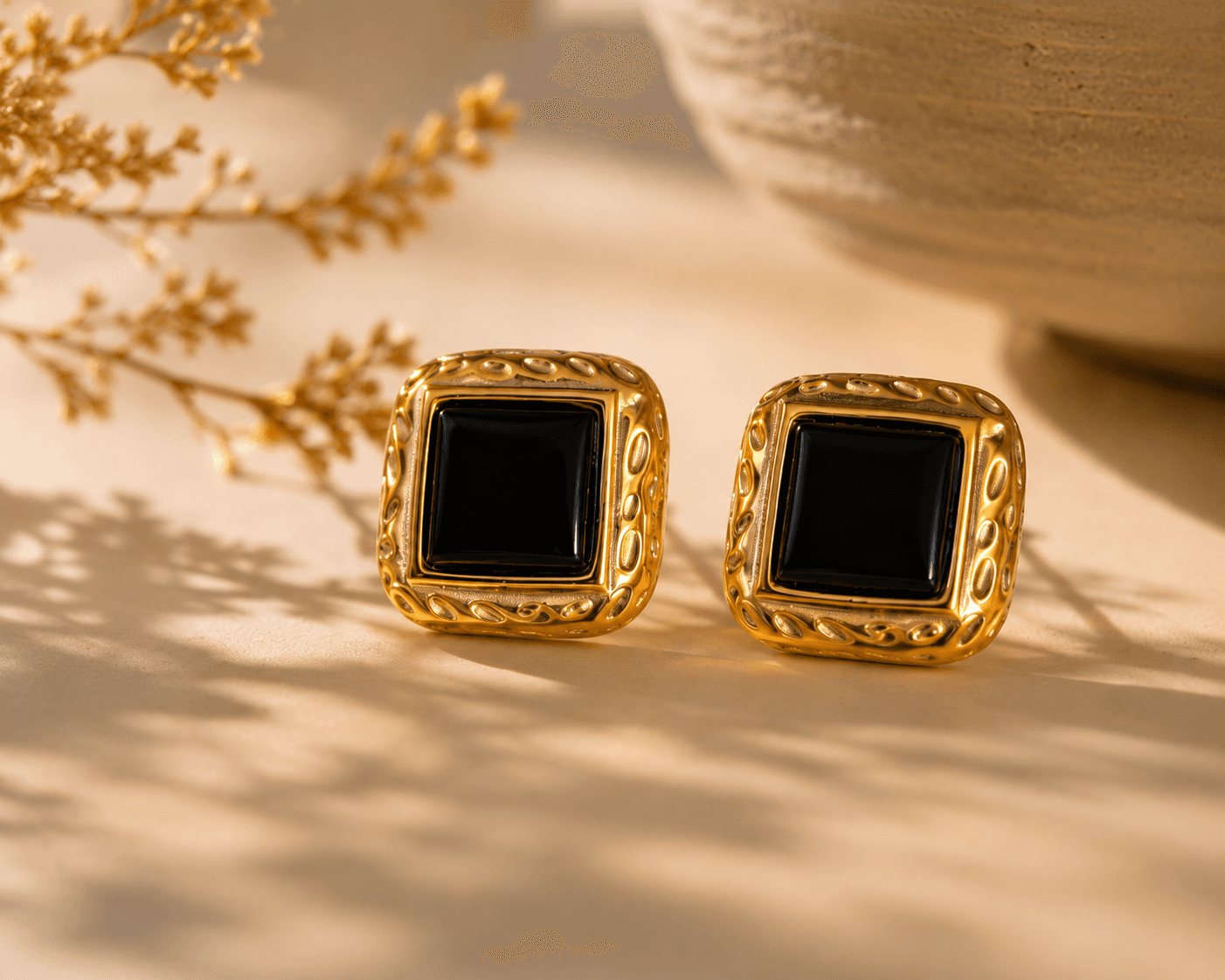 Boucles Onice posées sur surface crème, ombre de fleurs séchées, bol artisanal en terre, esprit d'atelier